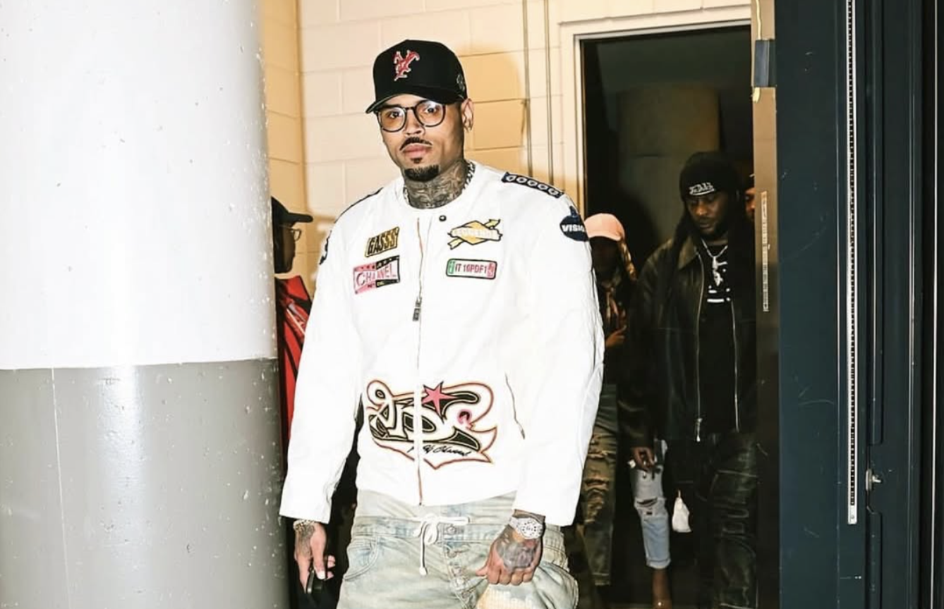 Man in stylish outfit and cap walking.